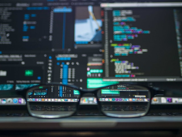 A photo of glasses infront of a computer screen.